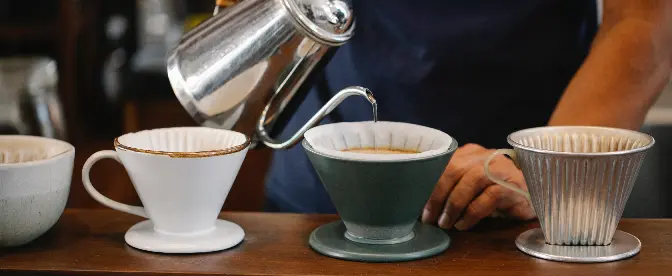 Primer vertido sobre el filtro con café molido en el embudo enfocado  preparación de café con filtro por goteo vierta sobre el método alternativo  de verter agua sobre los granos de café